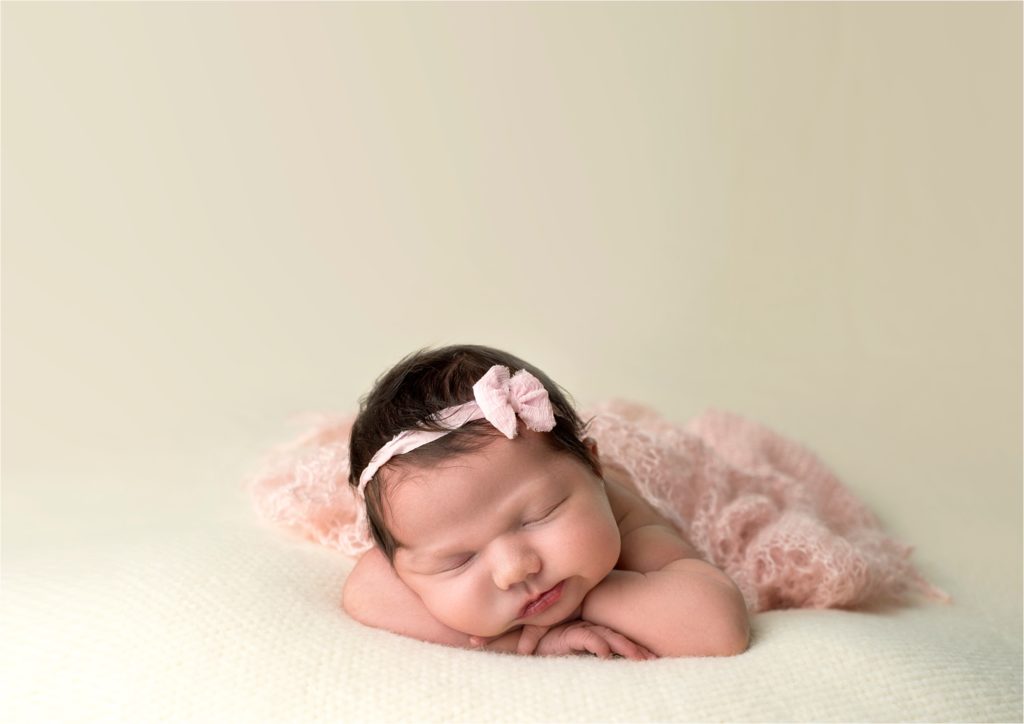 Angela Beransky Photography, San Diego newborn photographer, Newborn baby, Infant, baby photography, baby laying on the beige blanket, chin up pose with mohair wrap.