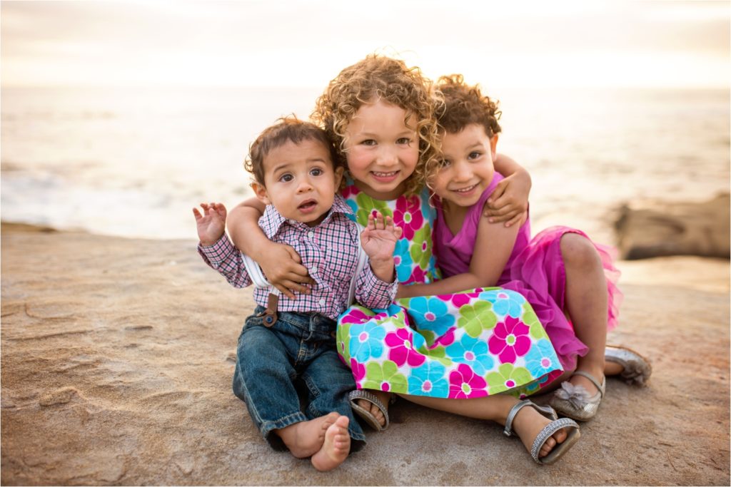 San Diego Family Photographer, Family Portraits San Diego, Windansea Beach, Wind and Sea beach, Family session with three kids. Siblings love, Siblings hug each other, three kids hugging on the beach