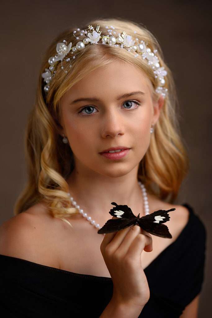 fine art portraits of a blond girl holding black butterfly by san diego family photographer