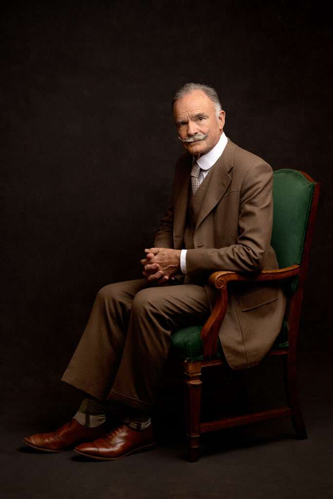 vintage studio portrait of a men in brown suit in a green chair by san dieog headshot photographer