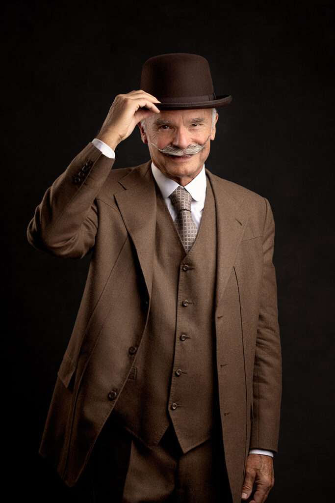 professional studio portrait of men in brown vintage suit holding black hat by san diego headshot photographer